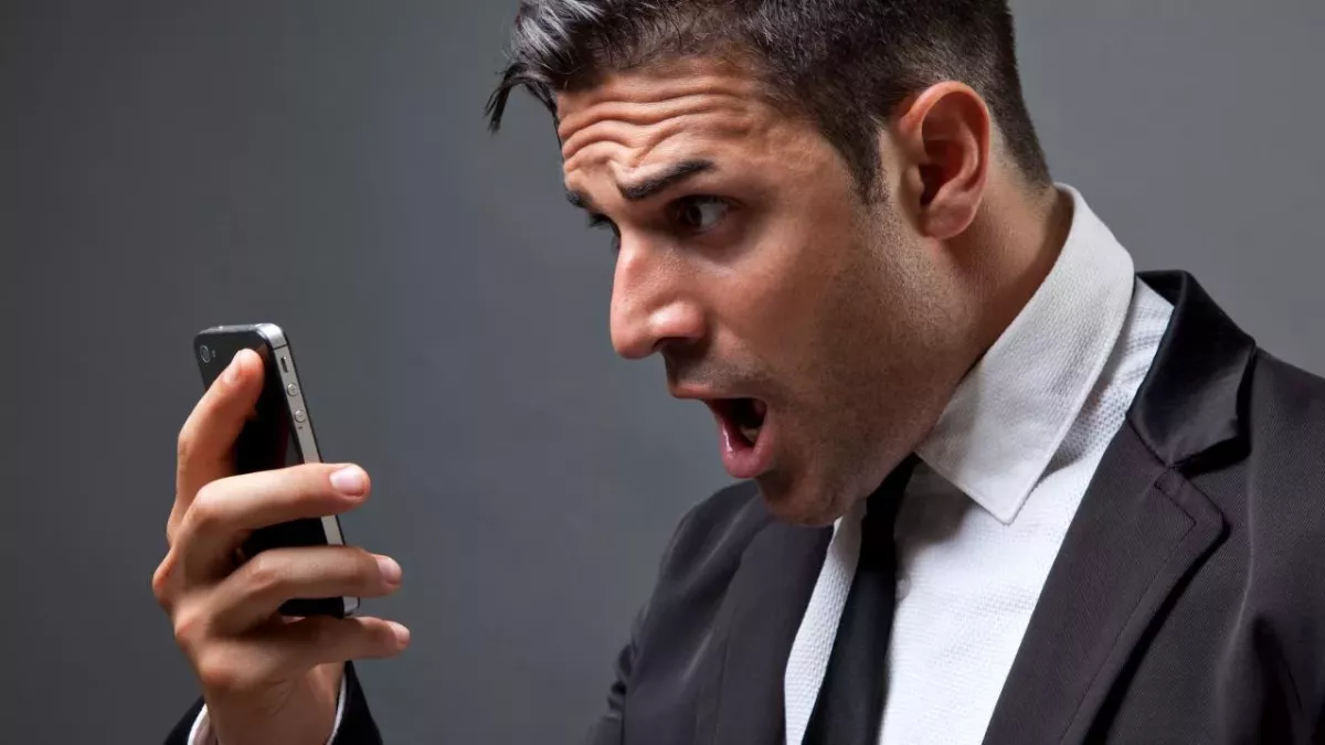 Un homme surpris face à son smartphone (illustration)