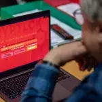 Un homme devant son ordinateur piraté