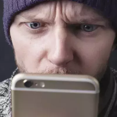 Un homme regardant son smartphone avec surprise (illustration).