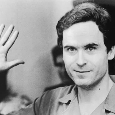 Ted Bundy saluant la caméra lors de l'un de ses procès